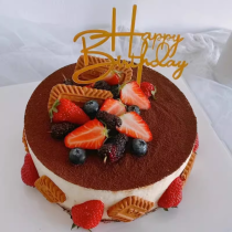 Tiramisu mousse birthday cake with strawberries, blueberries and biscuits