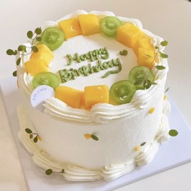 Runder Geburtstagskuchen mit grünen Trauben und Mangos