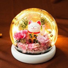 Fleurs rouges préservées et chat porte-bonheur chinois qui bouge la patte dans un dôme de verre