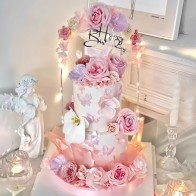 Pastel de cumpleaños de crema de leche en forma redonda de dos capas con flores en flor.