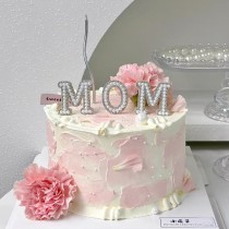 Bolo de aniversário para o Dia das Mães com tema "Amo a MÃE" e cravos-rosa frescos.