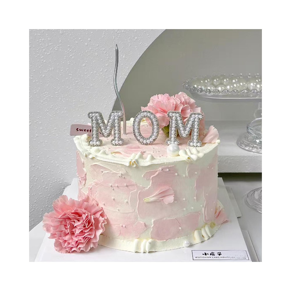 Bolo de aniversário para o Dia das Mães com tema "Amo a MÃE" e cravos-rosa frescos.