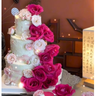 Bolo de aniversário de três camadas com flores frescas e frutas da estação.