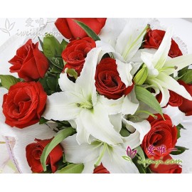 12 hochwertige rote Rosen, akzentuiert von 3 mehrstämmigen weißen Parfümlilien und frischem Grün.