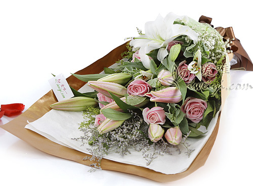 11 hochwertige rosa Rosen, akzentuiert durch 5 mehrstämmige rosa Sibirien-Lilien, 3 mehrstämmige weiße Duftlilien, Limonium perezii, Solidago, Baby's Breath, Euphorbia marginata und frisches Grün.
