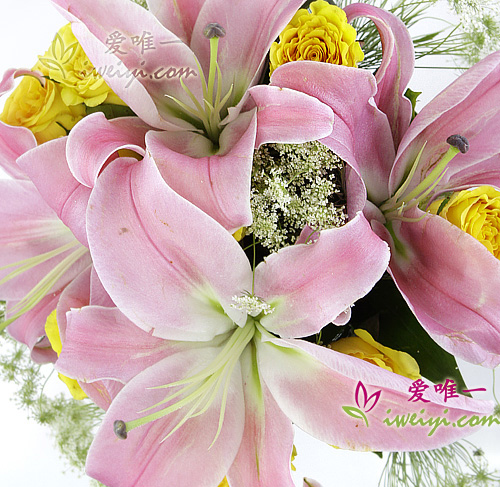 Glass vase composed of pink lilies and yellow roses