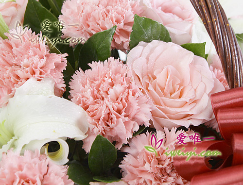 basket of flowers composed of pink roses, pink carnations and white perfume lilies